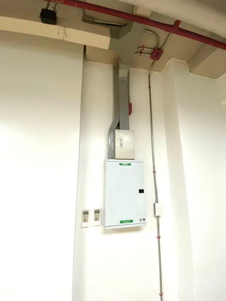 Office Space for rent in Khlong Toei, Bangkok - Electrical control panel and conduit mounted on a white office wall.