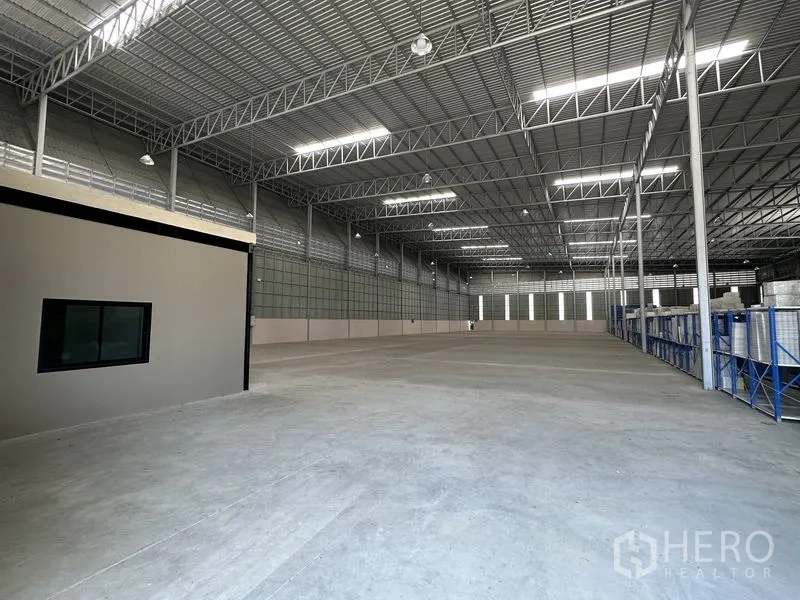 Factory for rent in Chachoengsao - Warehouse interior with attached office box, polished concrete floor and steel columns.