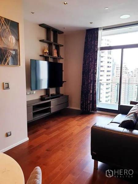 คอนโด ให้เช่าหรือขายในWatthana, Bangkok - ห้องนั่งเล่นทีวียึดผนัง ชั้นวางของ ประตูกระจกออกระเบียง มองเห็นวิวสกายไลน์