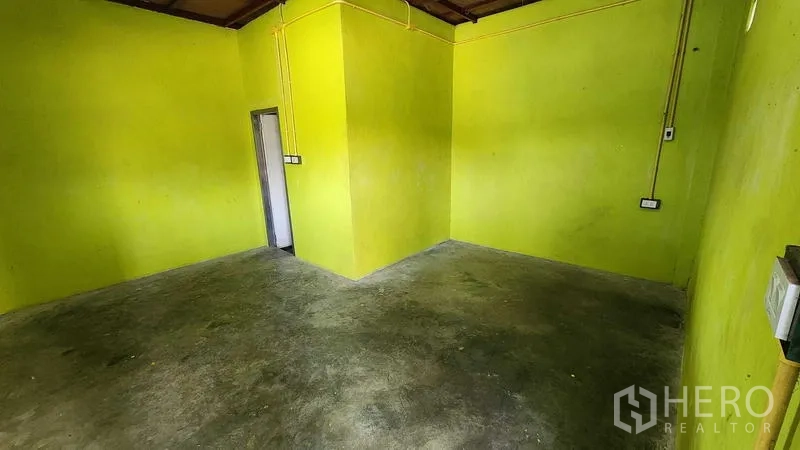 货栈 出租在Nong Chok, Bangkok - 仓库内绿色墙面的办公室房间，混凝土地面。