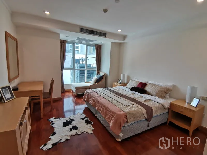 公寓 出租在Khlong Toei, Bangkok - 主卧配大床、飘窗休闲座椅、书桌与温润木地板。