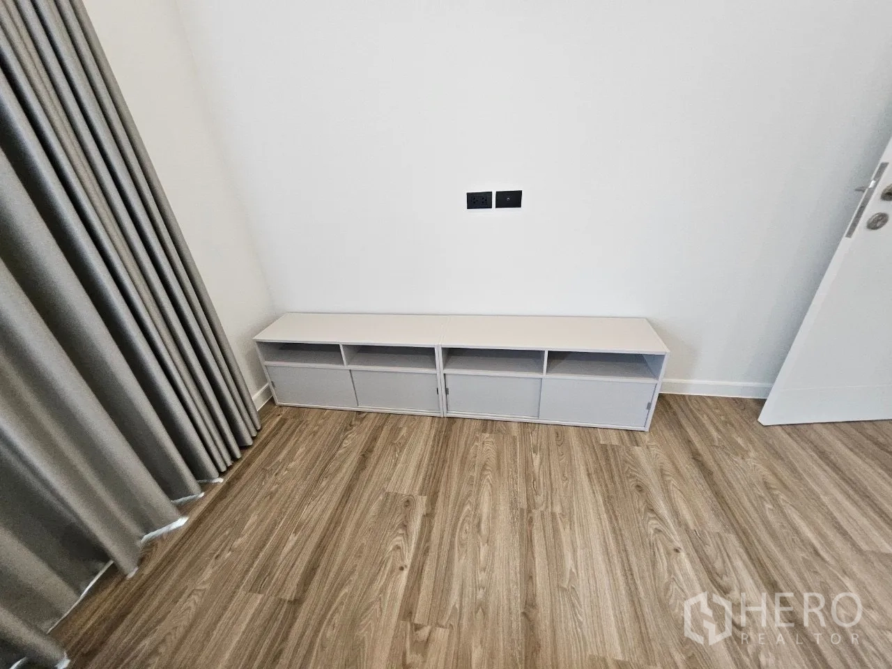 บ้าน ให้เช่าในBang Kapi, Bangkok - ผนังห้องนอนขนาดกะทัดรัดพร้อมตู้วางทีวีสีขาวและผ้าม่านสีเทา