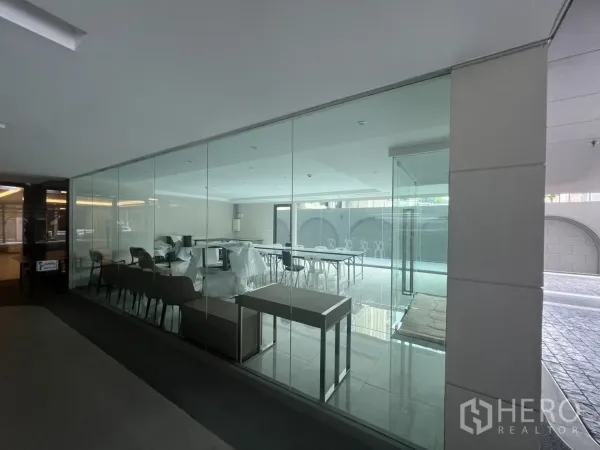 零售空间 出租在Watthana, Bangkok - 从走廊看见的玻璃店面，展示座位区与开放式布局。