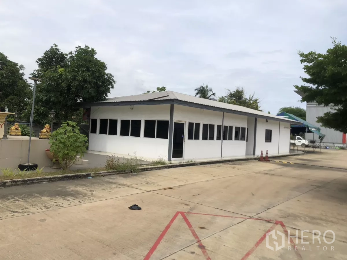 Factory for rent in Mueang Samut Prakan, Samut Prakan - Single-storey office block with a long row of windows facing the yard