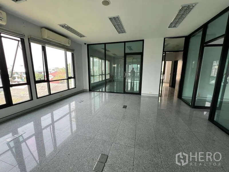 Office Space for sale in Bang Na, Bangkok - Open-plan office floor featuring glass meeting rooms and large windows.