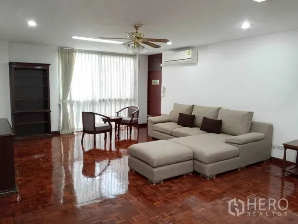 คอนโด ให้เช่าในWatthana, Bangkok - ห้องนั่งเล่นขนาดใหญ่ โซฟา L-shape พัดลมเพดาน และพื้นไม้เงา