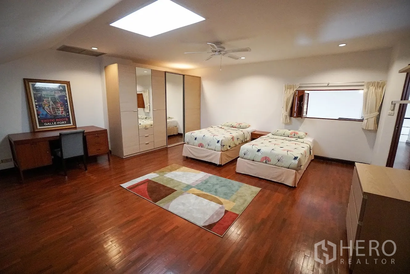 房间 出租在Watthana, Bangkok - 双床房另一角度，带衣柜与床头柜。