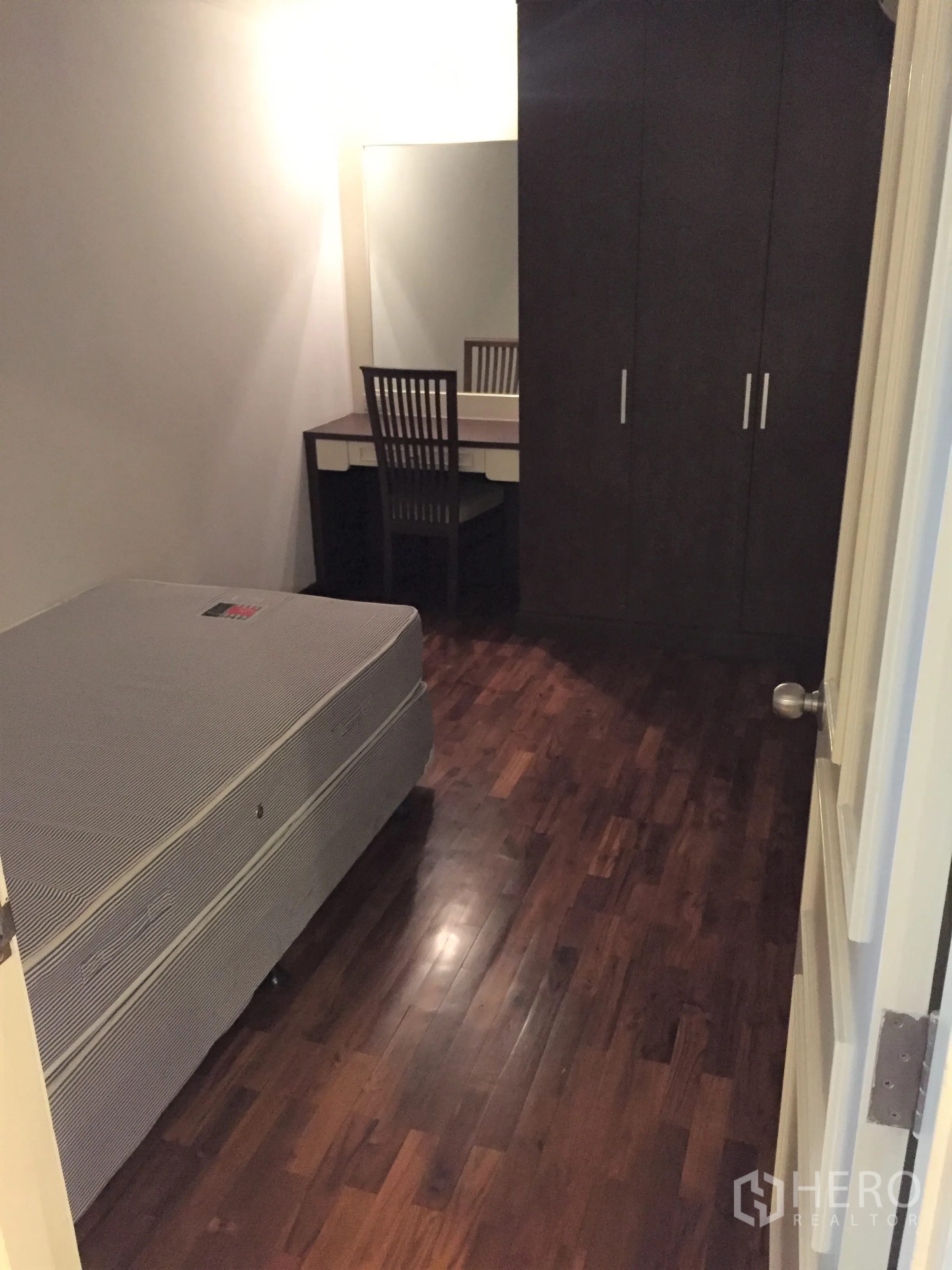 Condominium for rent in Watthana, Bangkok - Compact second bedroom with single bed, wardrobe and dressing table with mirror.