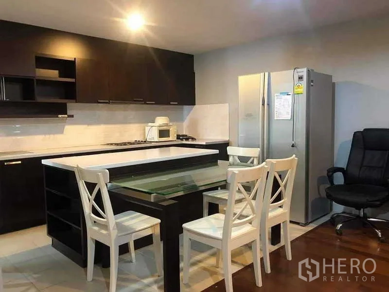 公寓 出售在Yan Nawa, Bangkok - 厨房角度展示不锈钢冰箱、深色橱柜与中岛座位。