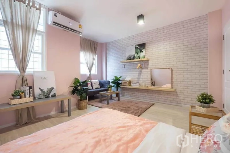 บ้าน ให้เช่าในKhlong Toei, Bangkok - ห้องนอนสีชมพูกว้าง ผนังอิฐโชว์ โซฟา และชั้นลอยพร้อมกระจก