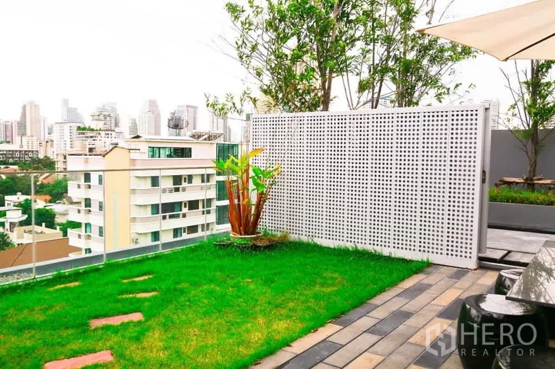 Condominium for rent in Watthana, Bangkok - Rooftop garden with lawn, glass railing and skyline views.