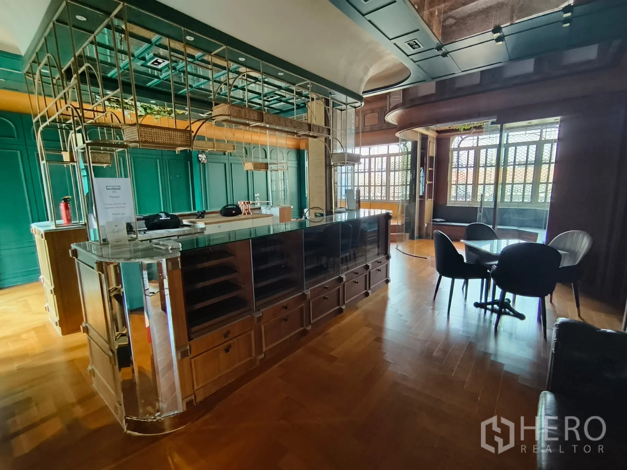 ตึกแถว for rent in Watthana, Bangkok - โซนเลานจ์พร้อมเคาน์เตอร์กระจก ชั้นโลหะ โต๊ะกลม และหน้าต่างโค้ง.