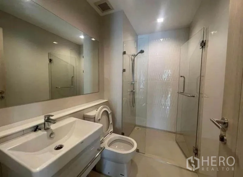 Condominium for rent or sale - Second bathroom with glass shower, toilet and wide vanity.