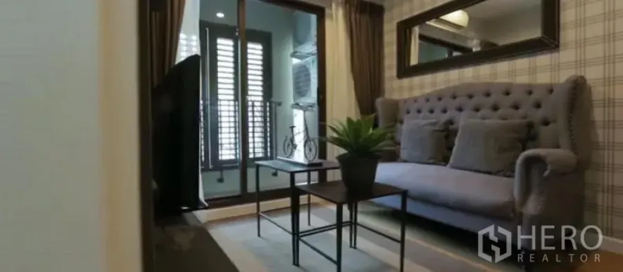 公寓 出租在Khlong Toei, Bangkok - 客厅配灰色纽扣沙发、茶几、长镜与阳台门。