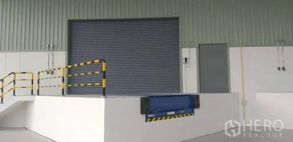 工厂 出租在Mueang Rayong, Rayong - 装卸月台配机械式登车桥、安全护栏和金属卷闸门。