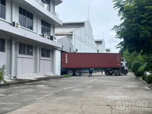 คลังสินค้า ให้เช่าในMueang Samut Prakan, Samut Prakan - รถบรรทุกตู้คอนเทนเนอร์เทียบท่าหน้าโกดัง ทางวิ่งกว้างมีแนวต้นไม้ สมุทรปราการ
