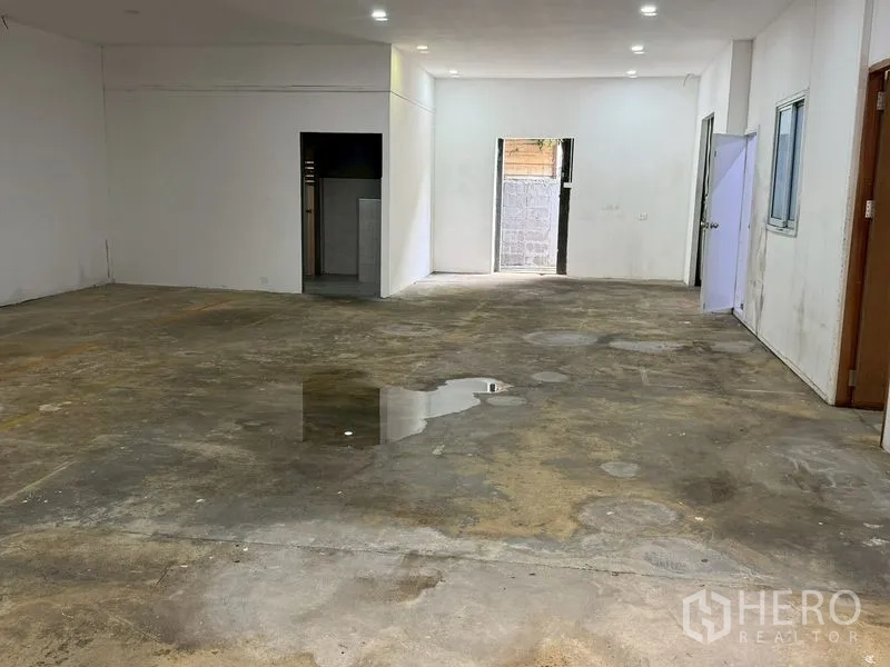Warehouse for rent in Lat Phrao, Bangkok - Multipurpose internal room with concrete floor, doors, and a window.