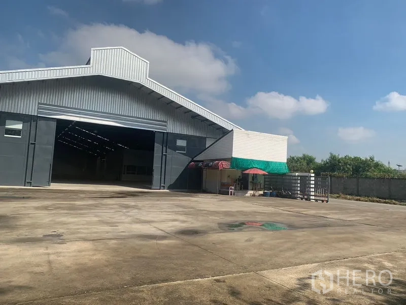 Warehouse for rent in Phra Pradaeng, Samut Prakan - Front of the warehouse with a huge loading yard, side canopy and secure gate in Samut Prakan.