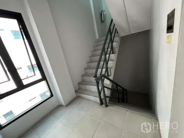 Office Space for sale in Bang Na, Bangkok - Bright stairwell with metal handrail and large opening window.