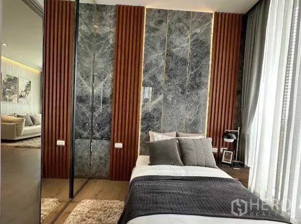 公寓 出售在Khlong Toei, Bangkok - 温馨卧室，石材背景墙与木质竖条装饰。