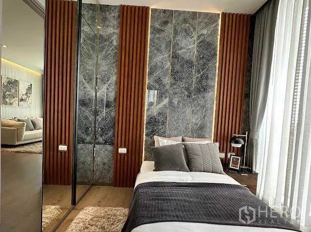 公寓 出售在Khlong Toei, Bangkok - 温馨卧室，石材背景墙与木质竖条装饰。