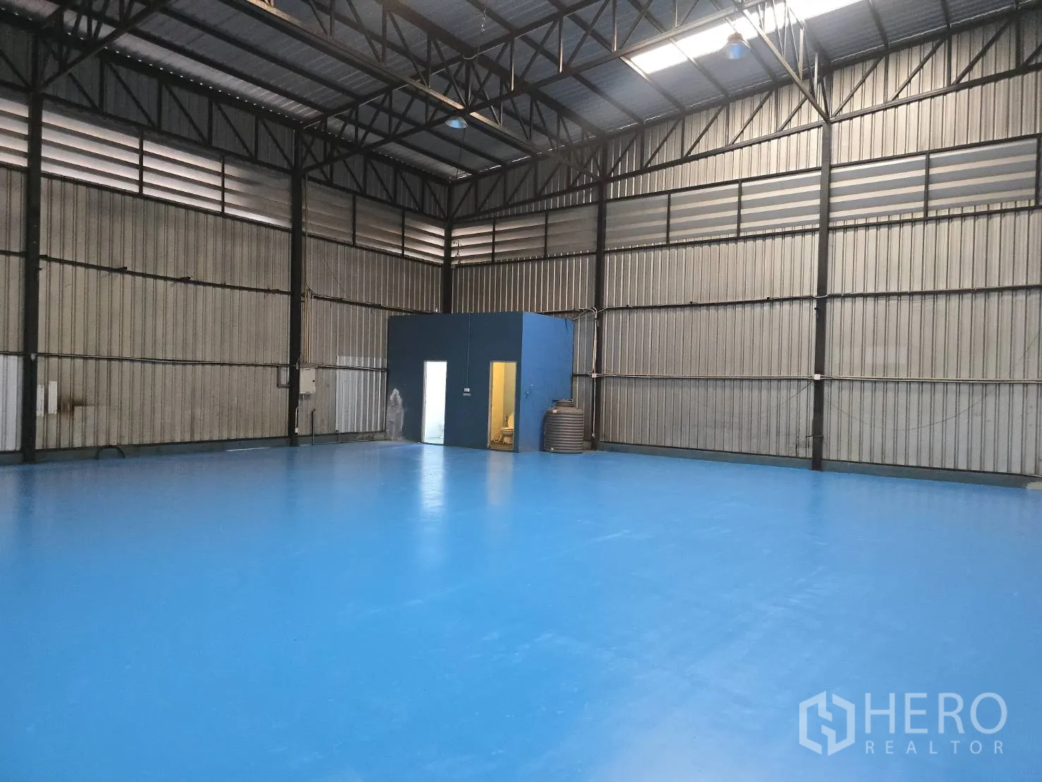 Warehouse for rent in Bang Phli, Samut Prakan - Open warehouse bay with steel trusses, ceiling lighting, and a small office unit.