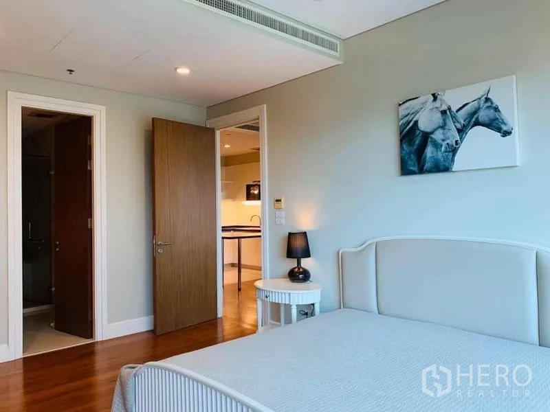 คอนโด ให้เช่าในKhlong Toei, Bangkok - ห้องนอนอบอุ่น เตียงบุผ้า โต๊ะข้างเตียง และทางเชื่อมสู่ห้องน้ำในตัว