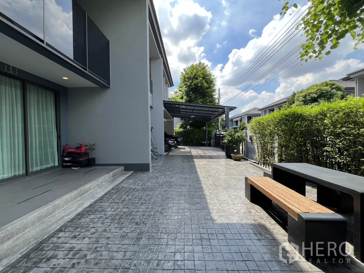 Detached House for rent or sale in Bang Kapi, Bangkok - Side walkway bordered by green hedges along the house.
