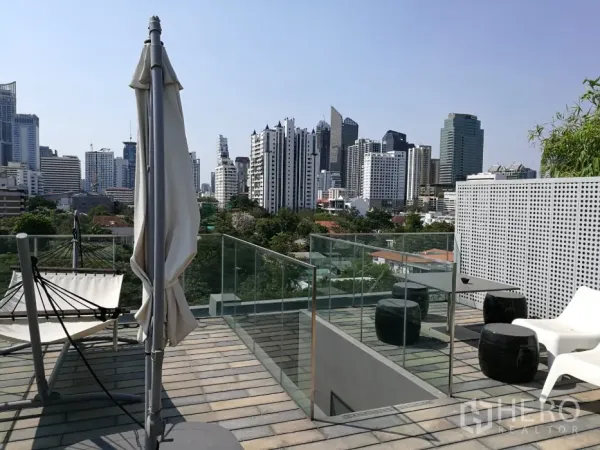 公寓 出租在Watthana, Bangkok - 屋顶露台配玻璃护栏，远眺曼谷城市天际线。