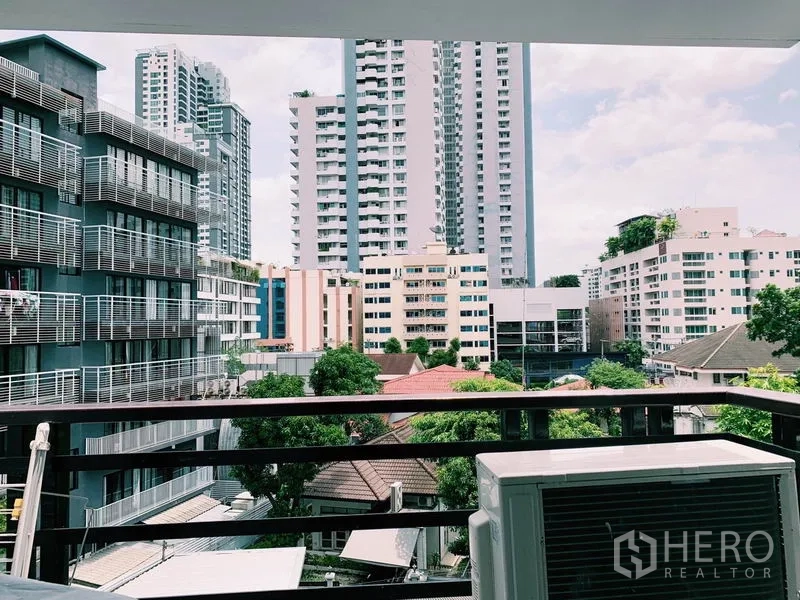 คอนโด ให้เช่าในWatthana, Bangkok - ระเบียงวิวเมืองย่านสุขุมวิท มองเห็นอาคารสูงและต้นไม้ พร้อมคอมเพรสเซอร์แอร์