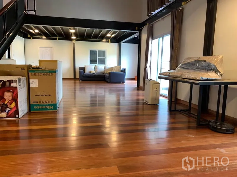 Home Office for rent in Lam Luk Ka, Pathum Thani - Bright mezzanine lounge with sliding doors and hardwood floors.