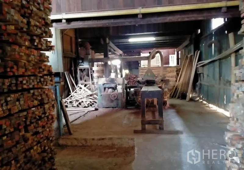 Warehouse for sale in Mueang Nonthaburi, Nonthaburi - Long covered loading bay with high roof and storage stacks along the wall.