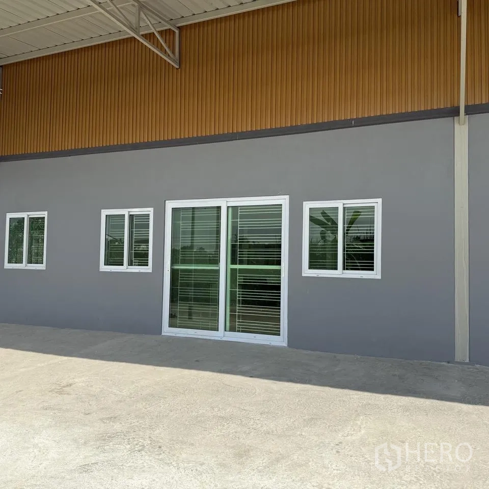 仓库 for rent or sale in Khlong Luang, Pathum Thani - 建筑正面有推拉玻璃门与窗户，前方为装卸坪。