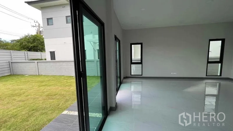 Detached House for sale in Bang Phli, Samut Prakan - Covered carport with gate and paved driveway facing the quiet community street.