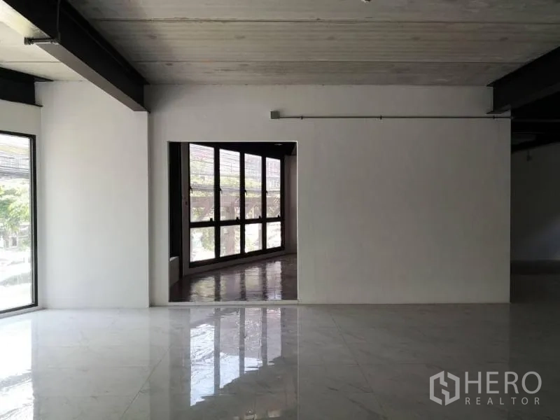 办公空间 出租在Chatuchak, Bangkok - 带门洞的隔墙，通向一条玻璃外墙的走廊与转角窗。