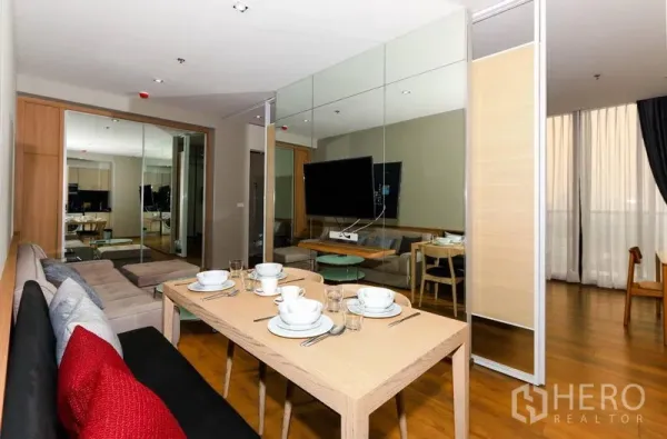 คอนโด ให้เช่าในKhlong Toei, Bangkok - มุมรับประทานอาหารพร้อมเบาน์ชซิทหันหน้าไปทางทีวีและผนังกระจก ผ้าม่านสูงจรดเพดาน