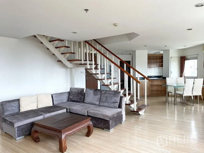 คอนโด ให้เช่าในKhlong Toei, Bangkok - พื้นที่นั่งเล่นแบบดูเพล็กซ์สว่าง โซฟาตัวแอล พื้นไม้ บันไดลอย และมุมรับประทานอาหารติดครัว