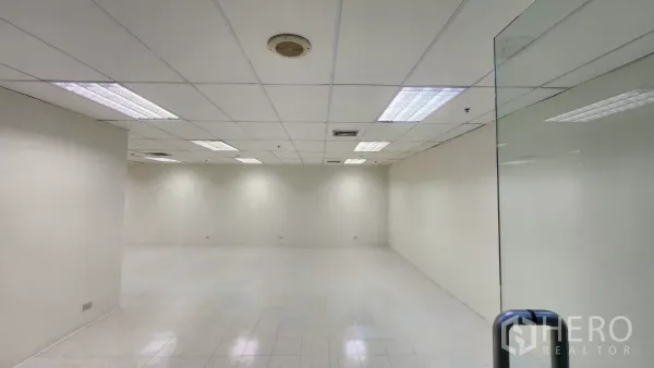 办公空间 出租在Watthana, Bangkok - 无窗办公区，吊顶栅格、荧光灯与空调出风口，白色地砖