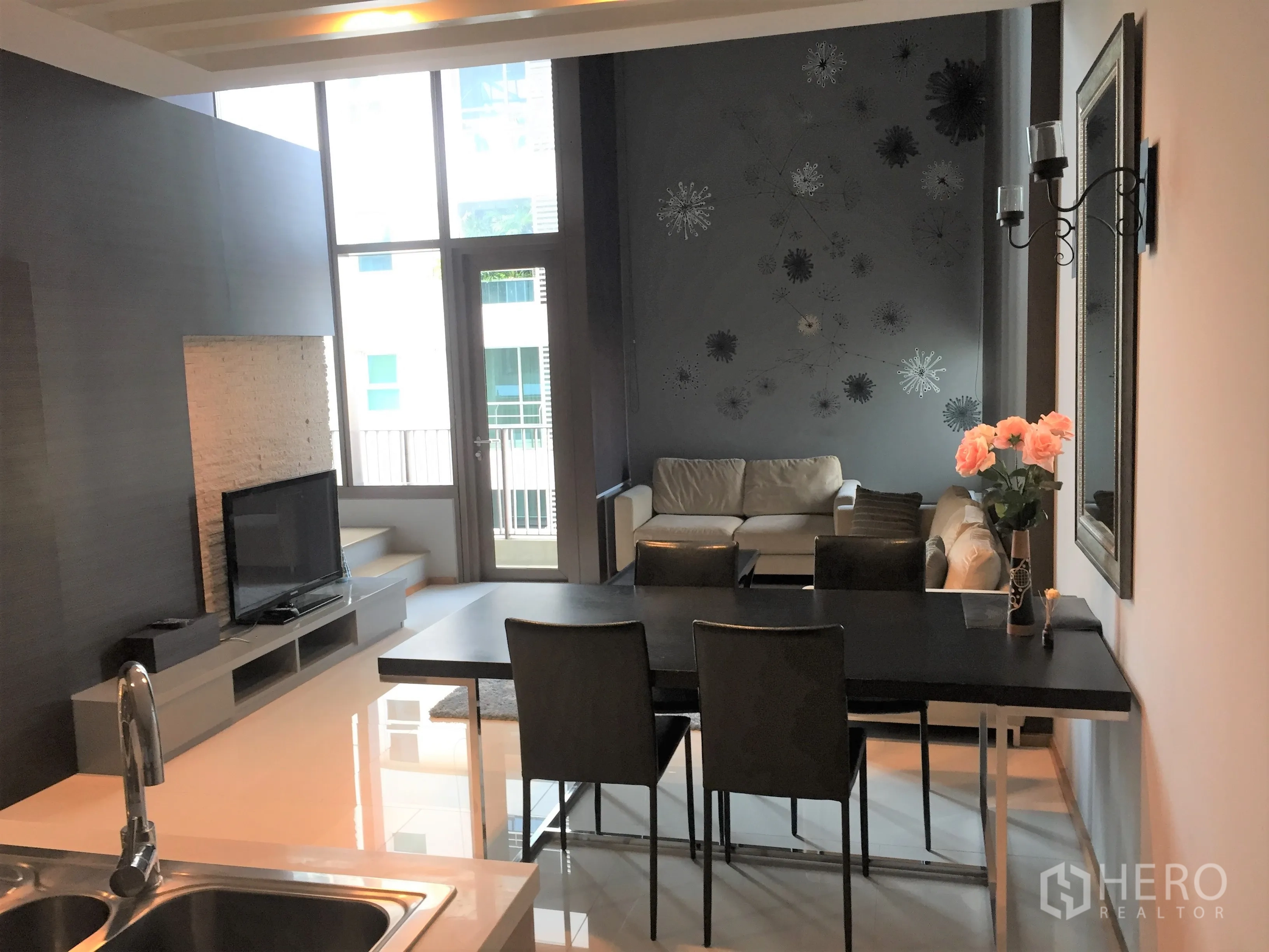 คอนโด ให้เช่าในKhlong Toei, Bangkok - พื้นที่นั่งเล่นและทานอาหารสว่างด้วยหน้าต่างเต็มบาน ประตูระเบียง ผนังตกแต่ง และทีวีจอแบน