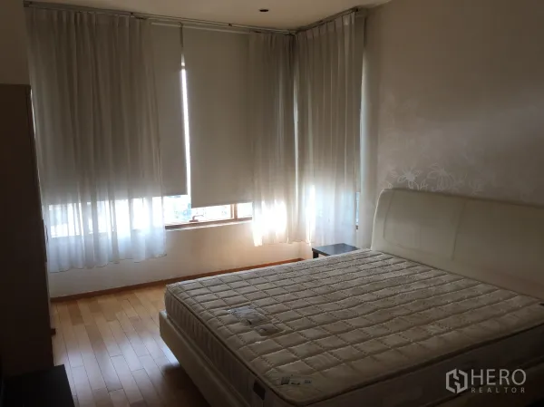 คอนโด ให้เช่าหรือขายในKhlong Toei, Bangkok - ห้องนอนหลักเตียงคิงไซส์ พื้นไม้ และหน้าต่างรอบห้องพร้อมม่านกรองแสง