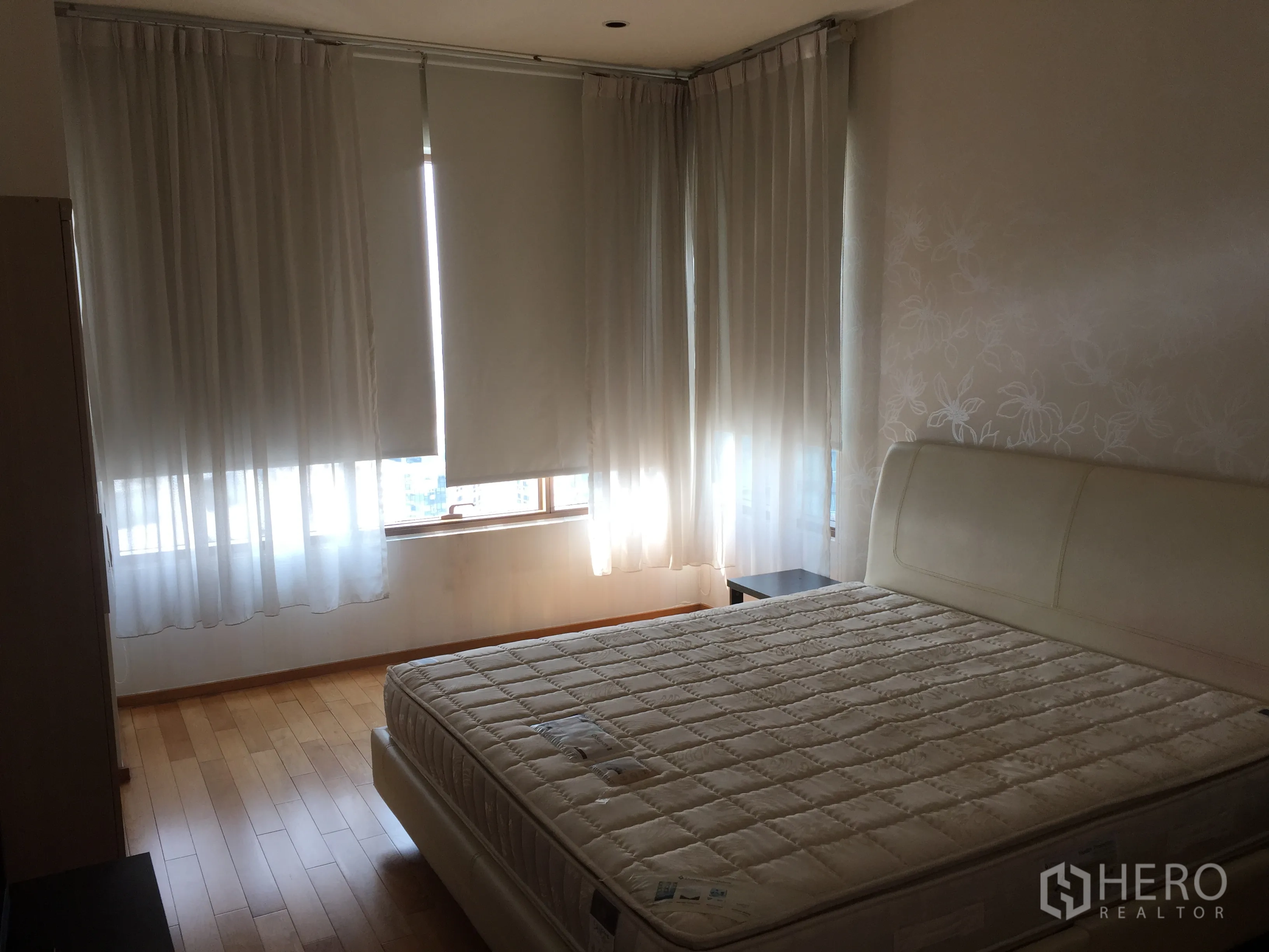 คอนโด ให้เช่าหรือขายในKhlong Toei, Bangkok - ห้องนอนหลักเตียงคิงไซส์ พื้นไม้ และหน้าต่างรอบห้องพร้อมม่านกรองแสง