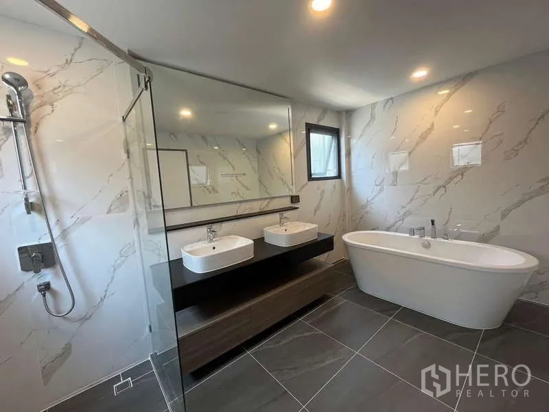 Detached House for rent or sale in Bang Phli, Samut Prakan - Luxury bathroom with freestanding bathtub, double vanity and glass shower.