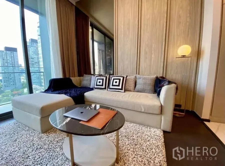 Condominium for rent in Watthana, Bangkok - Cozy living area with sofa, rug and round coffee table beside the balcony.