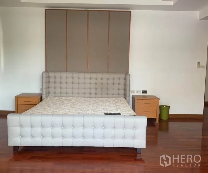 Detached House for rent in Din Daeng, Bangkok - Master bedroom with tufted upholstered bed and bedside tables.
