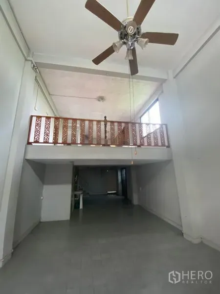Retail Space for rent in Khlong San, Bangkok - Double-height retail hall with mezzanine, ceiling fan and tiled floor.
