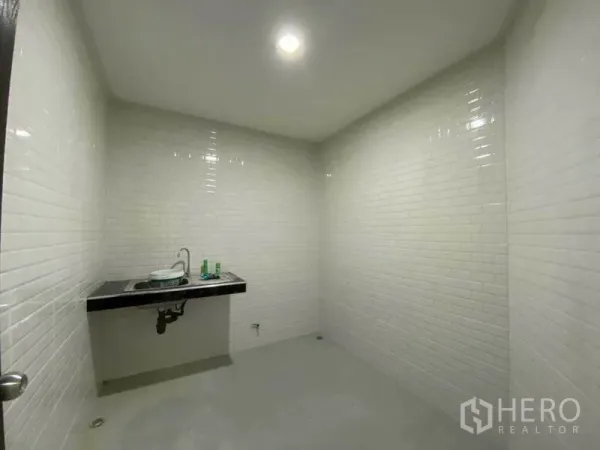 零售空间 出售在Khlong Toei, Bangkok - 茶水间/水槽房，黑色台面与白砖墙，水泥地面