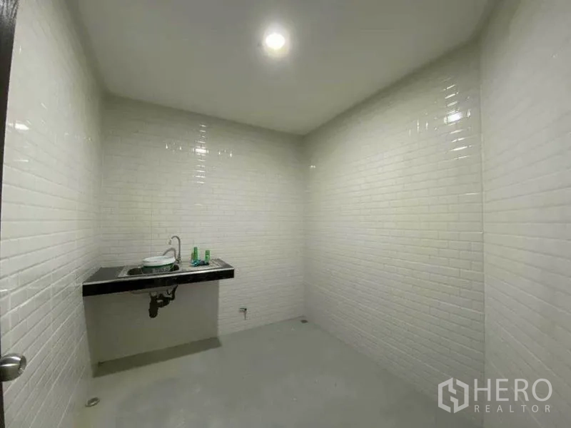 零售空间 出售在Khlong Toei, Bangkok - 茶水间/水槽房，黑色台面与白砖墙，水泥地面