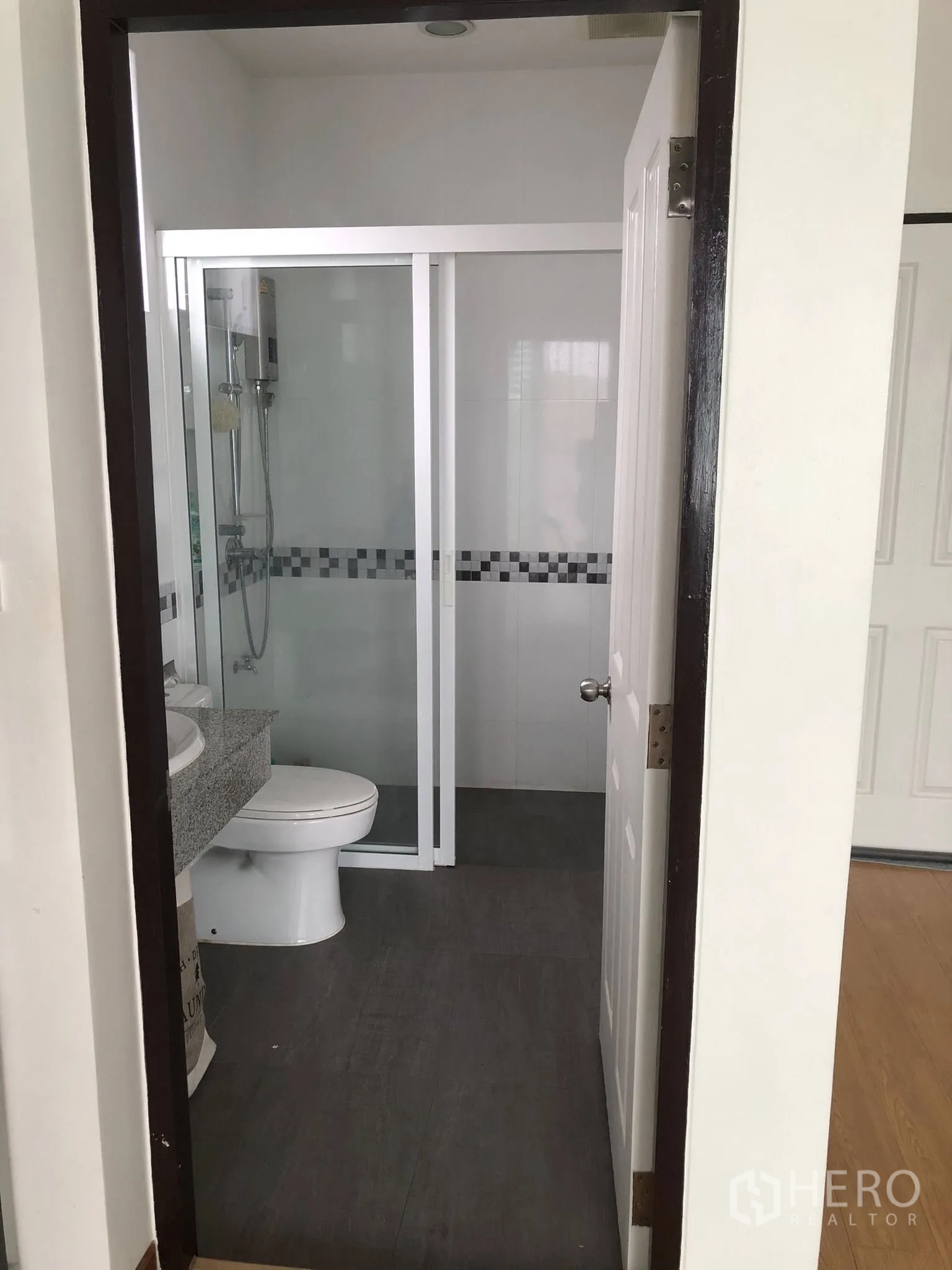 ทาวน์เฮาส์ ขายในPhra Khanong, Bangkok - ห้องน้ำสไตล์โมเดิร์นพร้อมตู้กระจกอาบน้ำ เคาน์เตอร์หินแกรนิต และพื้นกระเบื้องสีเทา