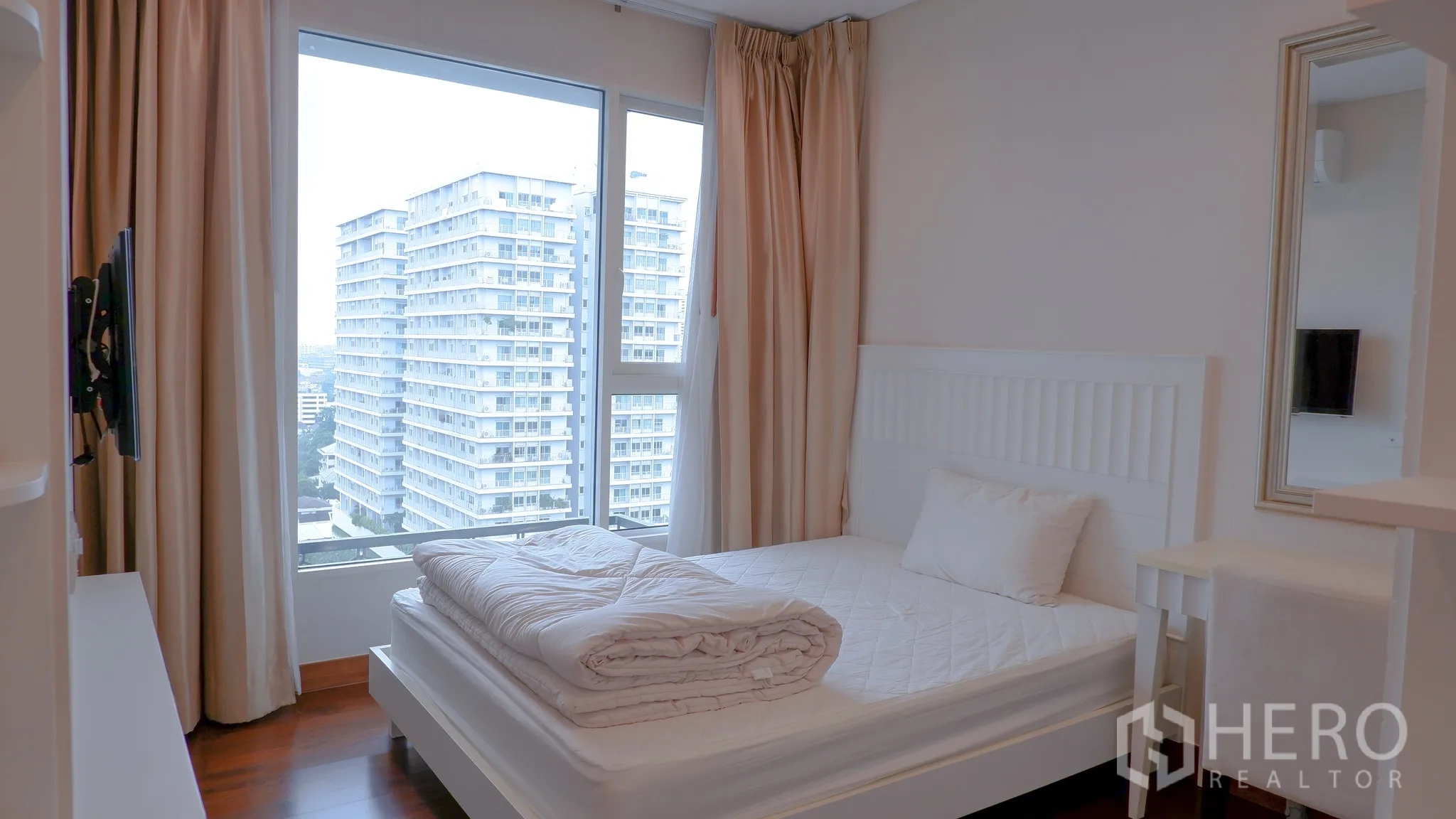 Condominium for rent in Watthana, Bangkok - Second bedroom from doorway with full-height mirror and soft drapes.