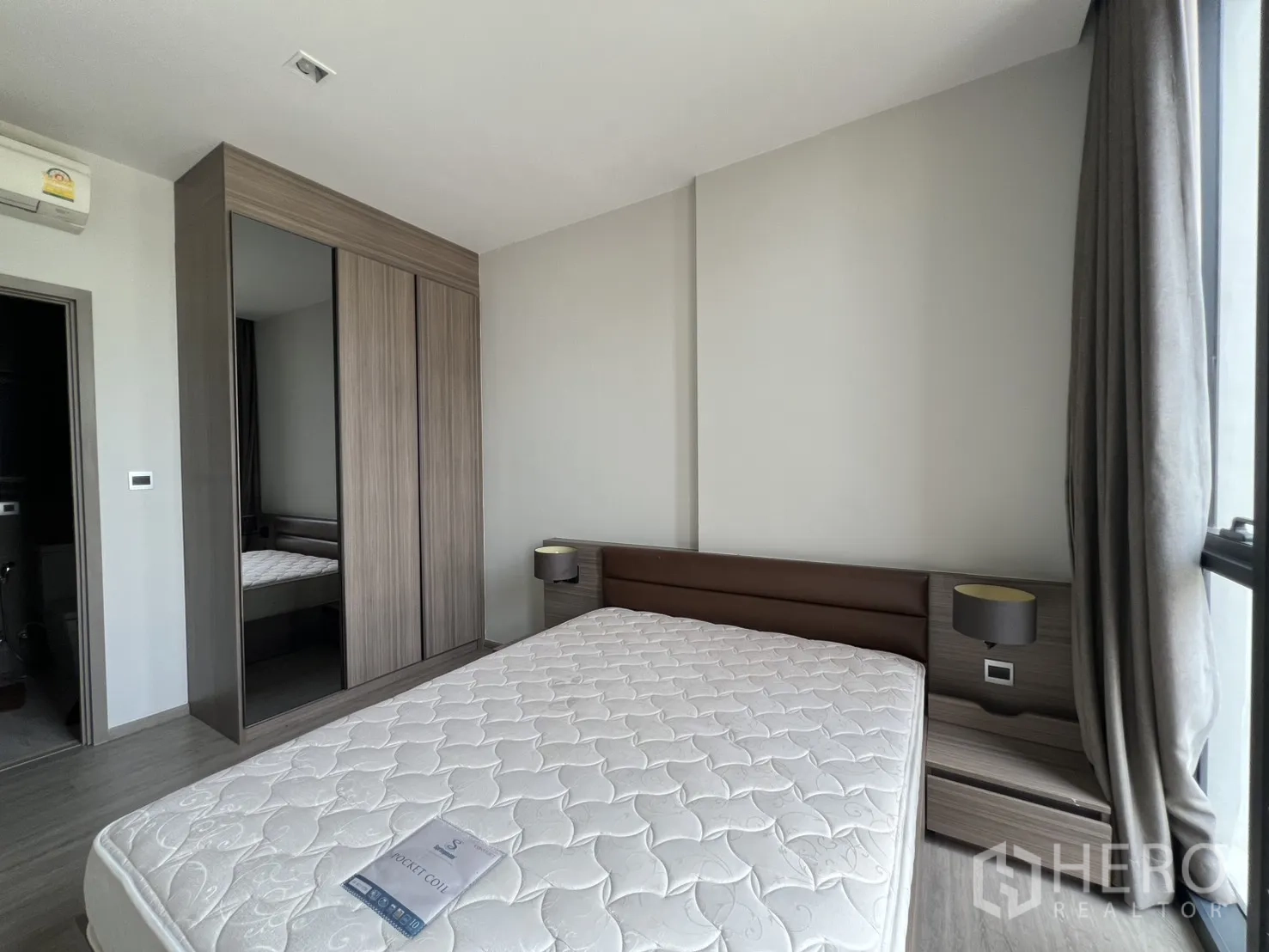 Condominium for rent in Watthana, Bangkok - Bedroom with bed, wardrobe, and a doorway leading to the bathroom.